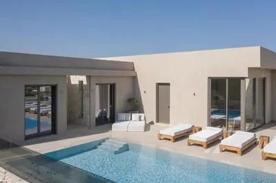 a villa with a swimming pool and a house at Amalthia Villa, Heated Pool & Walk to the Beach, By ThinkVilla in Tavronitis
