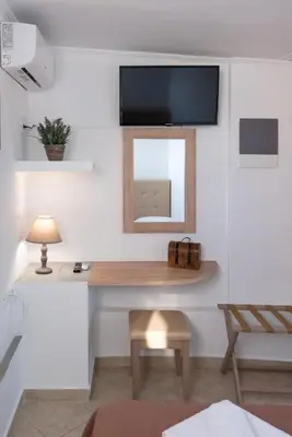 a living room with a mirror and a table at Calliope Rooms in Kissamos