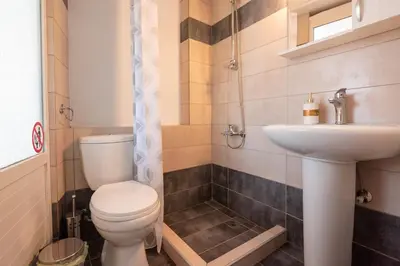 a bathroom with a toilet and a sink at Calliope Rooms in Kissamos