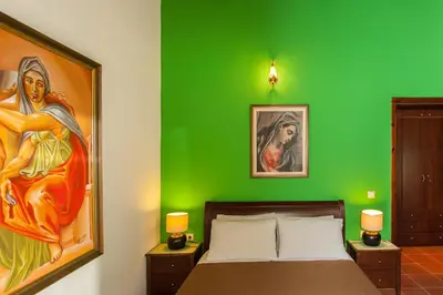 a green bedroom with a bed and a painting on the wall at Arhontika Villas in Élos