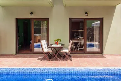 a patio with a table and chairs next to a pool at Arhontika Villas in Élos