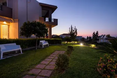 a backyard of a house at night with two benches at Tholos Apartments in Chania Town