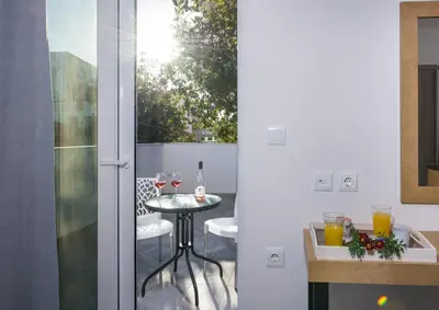 a glass door leading to a patio with a table and wine glasses at Deluxe City Hotel in Chania Town