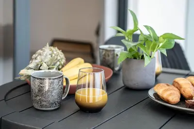 a black table with two cups and a plate of food at Nuovo Luxury Suites in Daratso