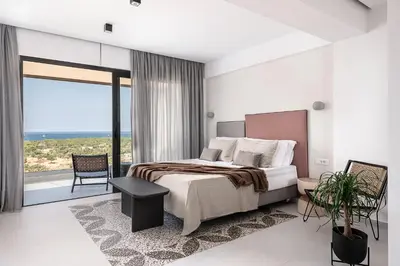 a bedroom with a large bed and a large window at Nuovo Luxury Suites in Daratso