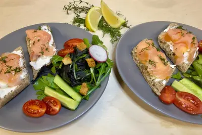 two plates of food with salmon and salad and tomatoes at Nuovo Luxury Suites in Daratso