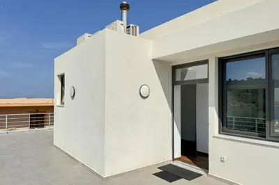 a white house with a large window on a roof at Villa Valentina Chania in Kalathas