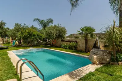 a swimming pool in a yard with a rock at Villa Eftychia - villa with 2 private pools!!! by PosarelliVillas in Almirida