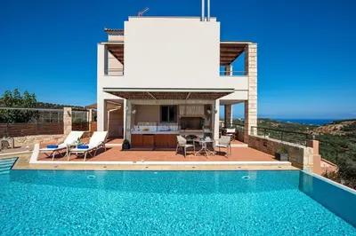 a villa with a swimming pool and a house at Margarita's Villas in Chania Town