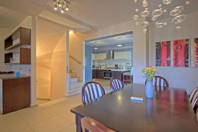 a dining room and kitchen with a table and chairs at Cabanavillas MILANO by PosarelliVillas in Agia Marina Nea Kydonias