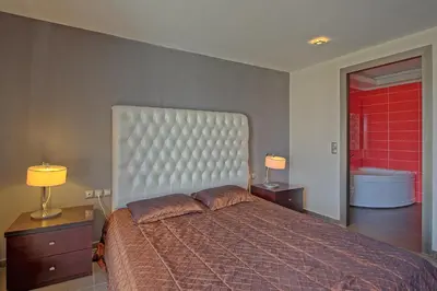 a bedroom with a large bed and two night stands at Cabanavillas MILANO by PosarelliVillas in Agia Marina Nea Kydonias