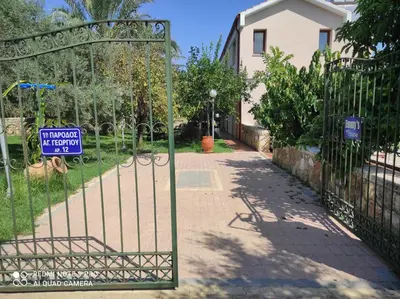 a gate with a sign in front of a driveway at Villa Koulouridi Agritourism in Daratso