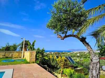 a view from the garden of a villa with a palm tree at Villa Koulouridi Agritourism in Daratso