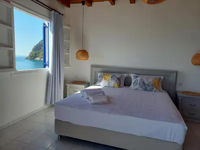 a bedroom with a bed with a view of the ocean at Hotel Agia Roumeli by the SEA in Agia Roumeli