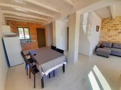 a kitchen and dining room with a table and a couch at Mitato Stylianos in Kounoupítsa