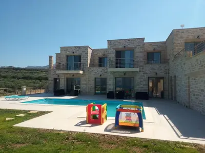 a villa with a swimming pool and a house at Mitato Stylianos in Kounoupítsa