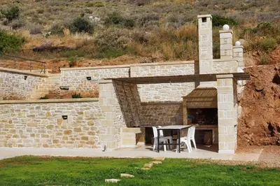 a brick oven with a table and chairs in it at Bangalows Stylianos in Kounoupítsa
