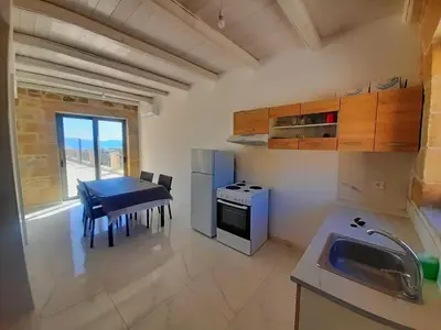 a small kitchen with a table and a stove at Bangalows Stylianos in Kounoupítsa