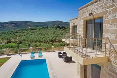 a villa with a swimming pool and a view at Bangalows Stylianos in Kounoupítsa