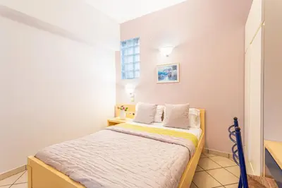 a small bedroom with a bed and a window at Anna Αpartments II in Agia Marina Nea Kydonias