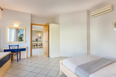 a bedroom with a bed and a kitchen and a table at Anna Αpartments II in Agia Marina Nea Kydonias