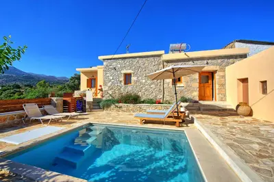 a villa with a swimming pool in front of a house at Villa Vicilla by PosarelliVillas in Fílippos