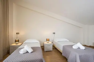 two beds in a room with white walls and wooden floors at Park View and near the Sea Villa with Private Pool 1 in Chania Town