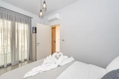 a white bedroom with a bed with white sheets at SUNRISE Spacious Apartment With 3 Bedrooms & 3 Bathrooms -Near to Chania in Kolymvari