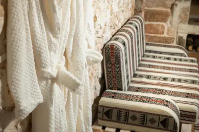 a row of white chairs against a stone wall at Beit Petra in Daratso