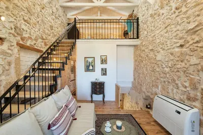 a living room with a stone wall at Beit Petra in Daratso