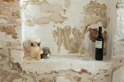 a bottle of wine sitting on a shelf in a wall at Beit Petra in Daratso