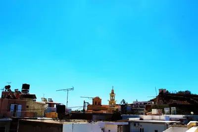 a view of a city with a clock tower in the background at Polydoros Hotel Apartments in Palaiochóra
