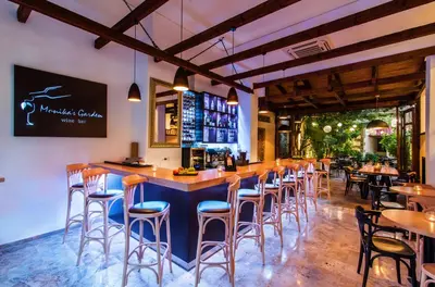 a bar with chairs and tables in a restaurant at Polydoros Hotel Apartments in Palaiochóra