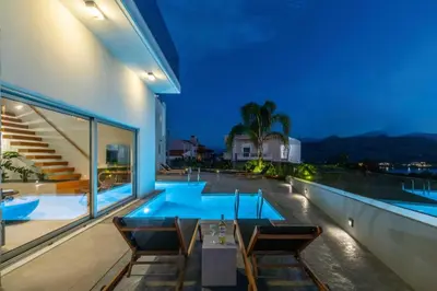 a patio with a table and chairs and a swimming pool at Villa Jarko in Chania Town