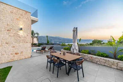 an outdoor patio with a wooden table and chairs at Villa Jarko in Chania Town