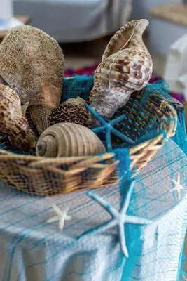 a basket filled with shells on top of a table at Blue Beach House in Kissamos