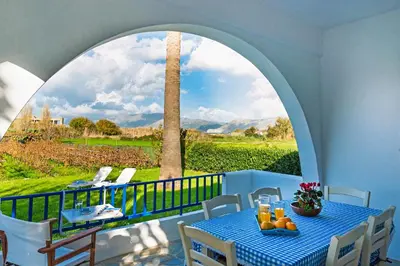 a table with oranges on a balcony with a large window at Blue Beach House in Kissamos