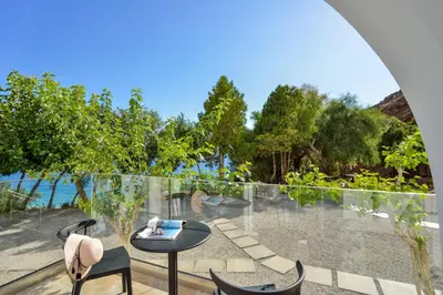an outdoor patio with a table and chairs and the ocean at Ilingas Mare in Khóra Sfakíon