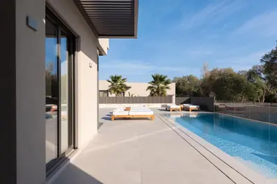 an external view of a house with a swimming pool at Athina Luxury Villa, with Pool & Walk to the Beach, By ThinkVilla in Chania Town