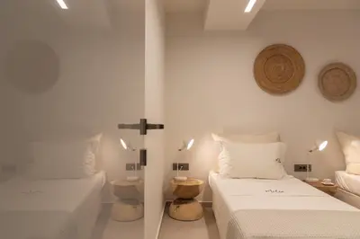 a bedroom with two beds and a cross on the wall at Athina Luxury Villa, with Pool & Walk to the Beach, By ThinkVilla in Chania Town