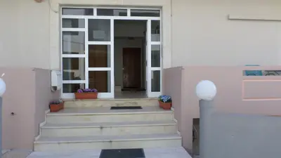 a white house with stairs leading to a door at Chania City Apartments in Chania Town