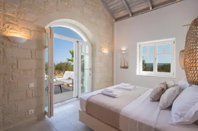 a bedroom with a bed and an open door to a patio at Villa Everlong in Vamos