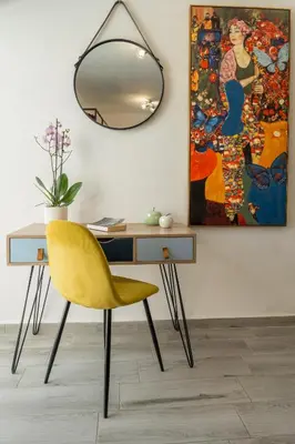 a desk with a yellow chair and a painting at Vista Magica in Chania Town