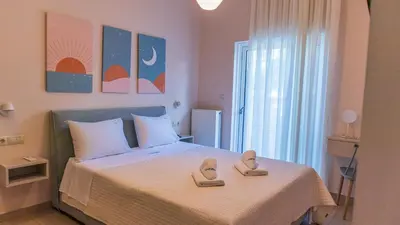 a bedroom with a bed with a pair of shoes on it at Happiness Luxury Home in Palaiochóra