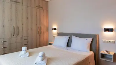 a bedroom with a bed with white shoes on it at Happiness Luxury Home in Palaiochóra