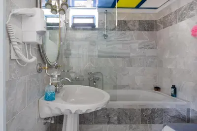 a bathroom with a sink and a bath tub at Plori - Molos Apartments in Loutro