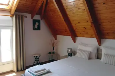 a bedroom with a white bed with wooden ceilings at Roof-Garden Apartment in Chania Town