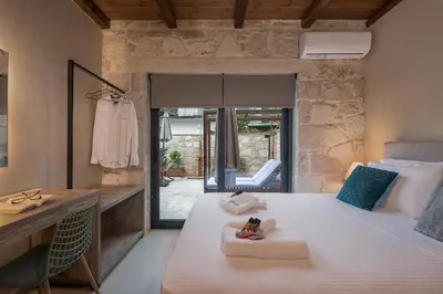 a bedroom with a large white bed and a chair at Villa Magnolia in Ayiá