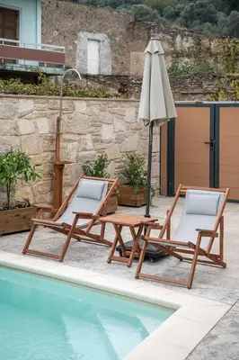 two lounge chairs and an umbrella next to a pool at Villa Magnolia in Ayiá