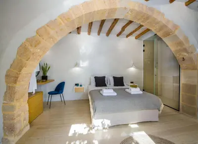 a bedroom with a bed in a room with an arch at Casa di Grimpili in Kolymvari